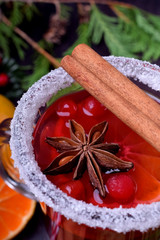 Hot mulled wine with slices of citrus fruits, cinnamon and anise in an Irish glass decorated with sugar border. Close-up