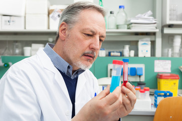 Naklejka na ściany i meble Scientist holding a test tube in his laboratory