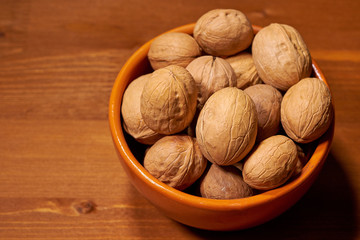 Walnut on brown wooden background. Selective focus