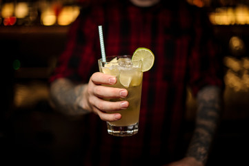 Barman holding a glass of fresh sour and sweet mojito cocktail