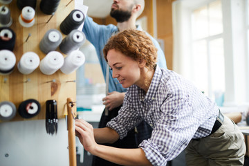 Casual young tailors working together in their workshop and preparing all necessary supplies for...