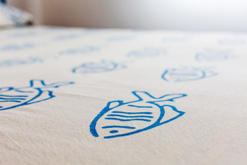 White bed sheets with blue fish pattern. Bedroom