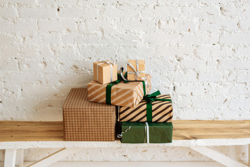 Fototapeta premium Christmas gift boxes on white brick wall background