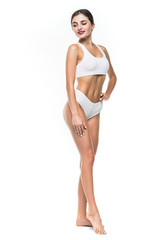 Fototapeta premium Happy young slim woman with beautiful perfect body posing on white background. Full-length portrait