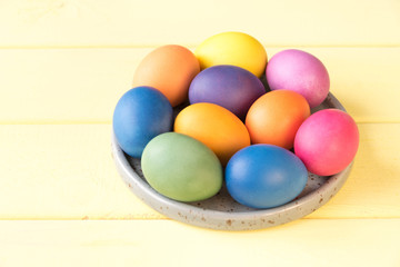 Fototapeta na wymiar Easter eggs on a plate. Yellow background