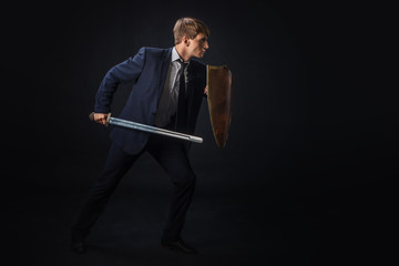 Businessman with shield and sword in the fighting rack, free space on the right. Anti-virus