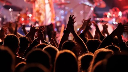 Night concert crowd raise and clap their hands in front of stage lights - Powered by Adobe