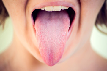 Closeup portrait of young woman showing her tongue © Aleksej