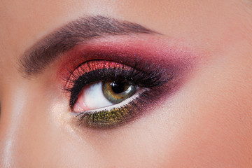 Fototapeta na wymiar Amazing Bright eye makeup in luxurious scarlet shades. Pink and blue color, colored eyeshadow