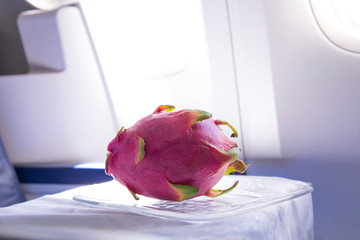 fresh pink dragonfruit on the table in the plane for dinner during flight to tropic country