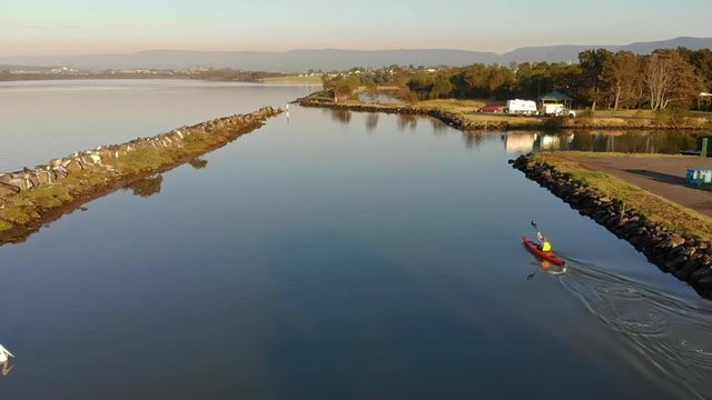 Several different shots of someone paddling a Kayak on a lake in Berekely, NSW, Australia