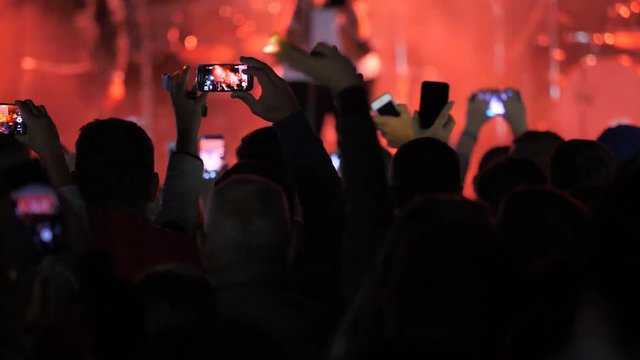 Fans crowd waves hands and takes photos with mobile smart phones