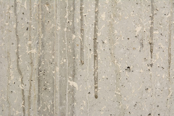 Glatte Betonwand ohne Schalungsstruktur mit Gipsspritzer und heruntergeronnenem Zement.