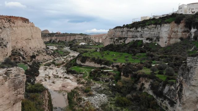 Drone video 4k acantilados rio seco. Pueblo al borde de un barranco. Monta&ntilde;as rocosas y laderas de hierba verde. Espa&ntilde;a