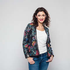 Portrait of smiling young woman in colorful bomber jacket