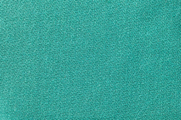 Green fabric background texture. Detail of textile material close-up