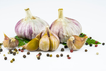 The heads of garlic and mix of colored peppers isolated on a white background.