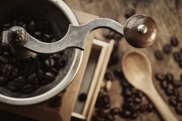 Old vintage coffee grinder with grains of coffee on a wooden table. retro style.  Copy-space. selective focus.