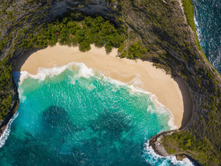 Aerial view of the Kelingking beach located on the Nusa Penida island. Turquoise water, white waves and clear sand. Photo from drone. Indonesia.