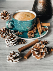 turquoise cup of hot coffee with cinnamon sticks on grey background