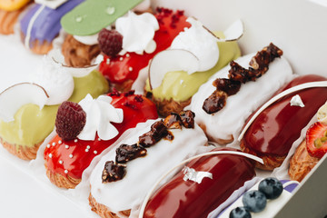 Set of delicious eclairs with glaze, colorful dessert