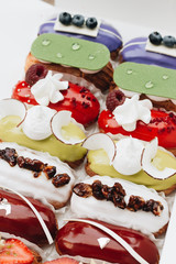 Set of delicious eclairs with glaze, colorful dessert