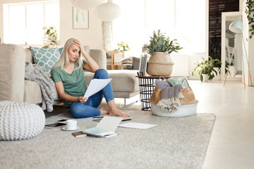 Worried woman reading documents at home