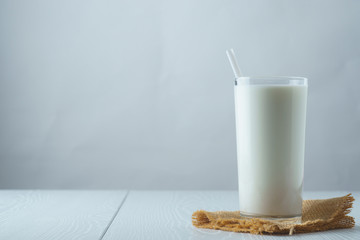 A glass of milk with a straw on a white background