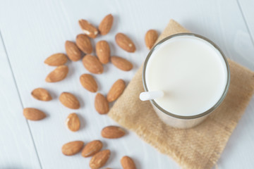 Obraz na płótnie Canvas A glass of milk on a napkin top view, almonds