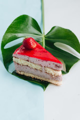 Piece of delicious strawberry cake with monstera leaf