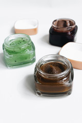 Assortment of different jams in small jars on white background, top view