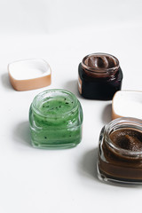 Assortment of different jams in small jars on white background, top view