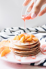 Stack of delicious homemade pancakes with sauce and sliced apple