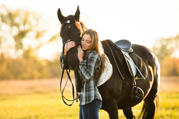 Obraz premium Girl equestrian rider stands near the horse. Horse farm. Horse theme 