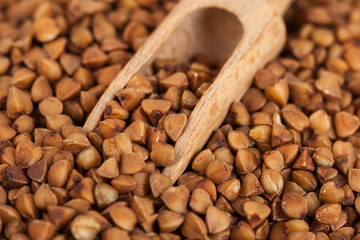 Group of buckwheat groats in a wooden spoon, healthy food