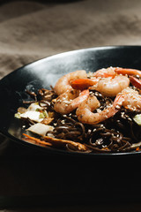 Delicious meal with shrimps in black plate, traditional Aisan food
