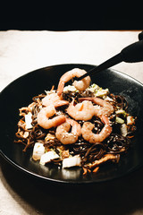 Delicious meal with shrimps in black plate, traditional Aisan food