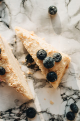 Piece of delicious cake with blueberries on marble table, sweet dessert