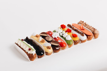 Set of delicious eclairs with glaze, colorful dessert