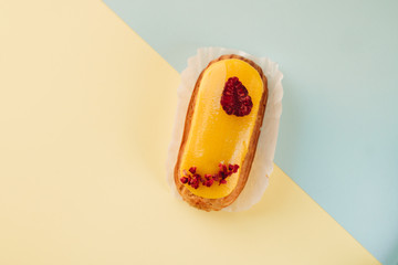 Delicious eclair with yellow glaze, sweet dessert