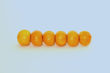 horizontal line of unpeeled clementines isolated on white