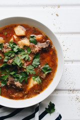 Delicious tomato soup with parsley, meat and pepper