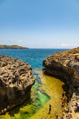Fototapeta premium NUSA PENIDA, INDONESIA - OCTOBER 23, 2018: Tourists at Angel's Billabong beach, the natural pool on the island Nusa Penida.