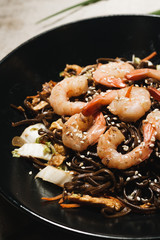 Delicious meal with shrimps in black plate, traditional Aisan food