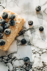 Piece of delicious cake with blueberries on marble table, sweet dessert