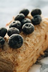 Piece of delicious cake with blueberries on marble table, sweet dessert