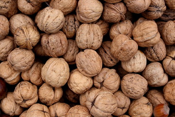 Many walnut brown nuts in shell on the market background pattern