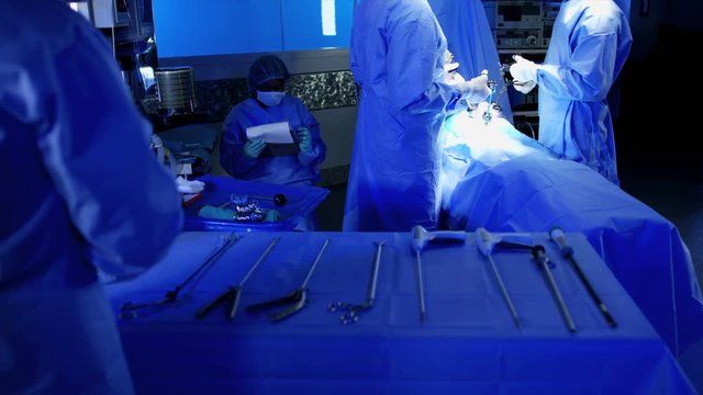 Endoscopy surgical instruments and tools with camera video technology being used by surgical training team in scrubs to perform a Laparoscopy operation 