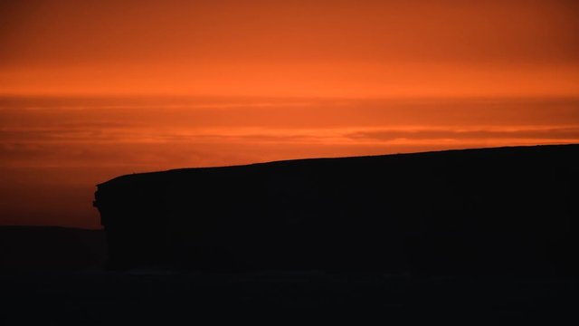 Scotland sunrise over cliff edge with birds in the sky