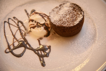 Chocolate muffins with chocolate syrup and ice cream .